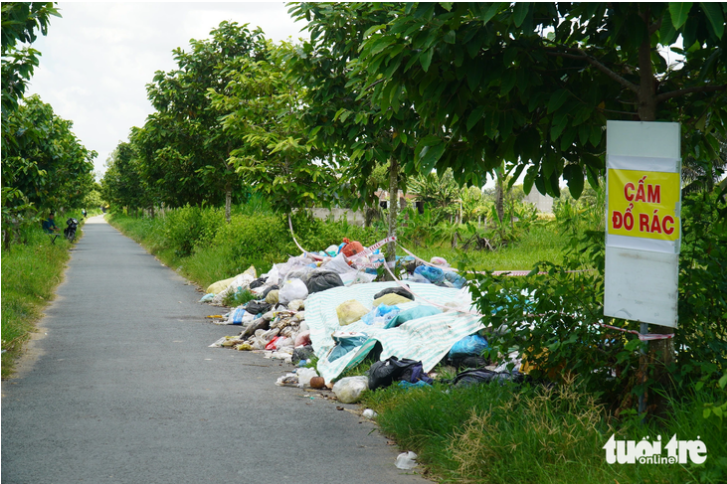 Garbage on a road in Ba Tri District, Ben Tre Province despite a signboard of “No littering” and local officials’ patrols