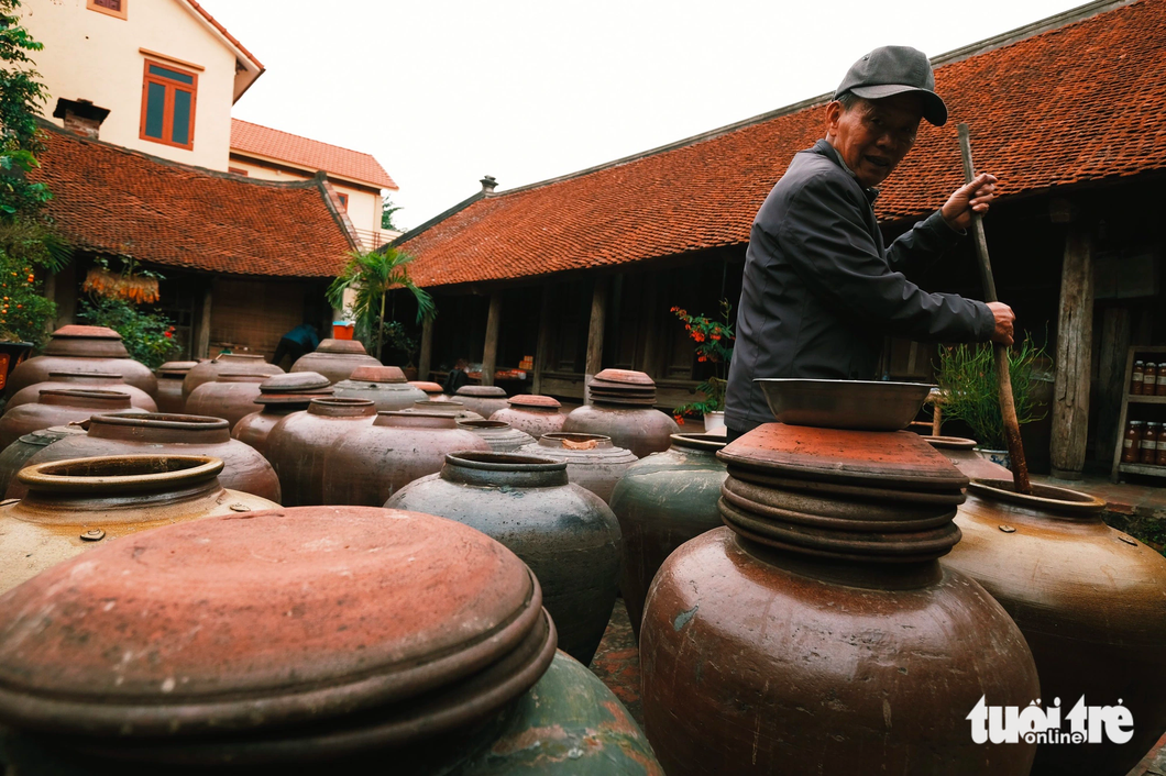 A man stirs tương nếp (fermented sticky rice paste) in Hanoi’s Duong Lam Ancient Village. Photo: Mai Thuong / Tuoi Tre
