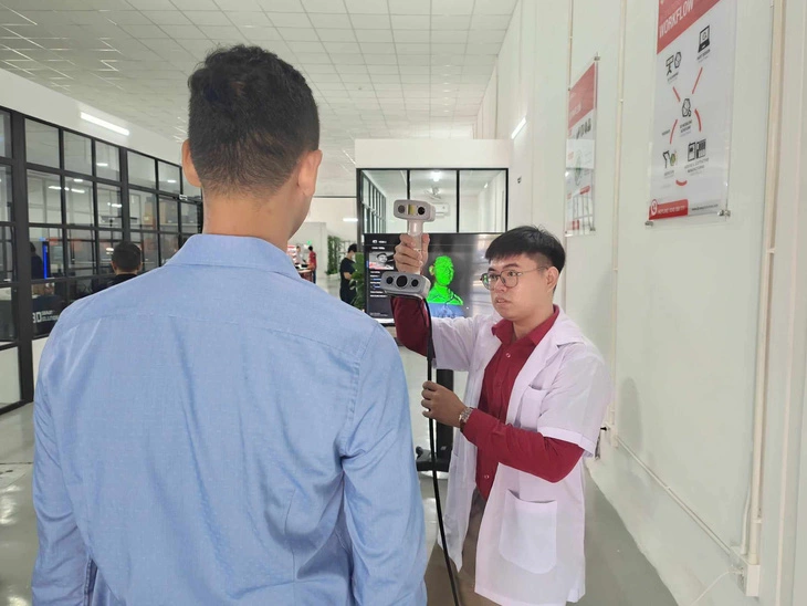 The full-body 3D scanning process is carried out using a compact and lightweight handheld scanner at the 3DS 3D printing workshop in Thu Duc City, Ho Chi Minh City. Photo: Duc Thien / Tuoi Tre