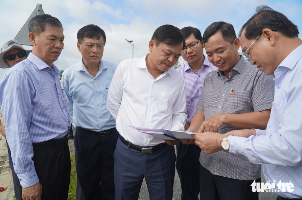 Deputy Minister of Agriculture and Rural Development Nguyen Hoang Hiep (L, 3rd), and other officials survey a landslide site in Tien Giang Province. Photo: Mau Truong / Tuoi Tre