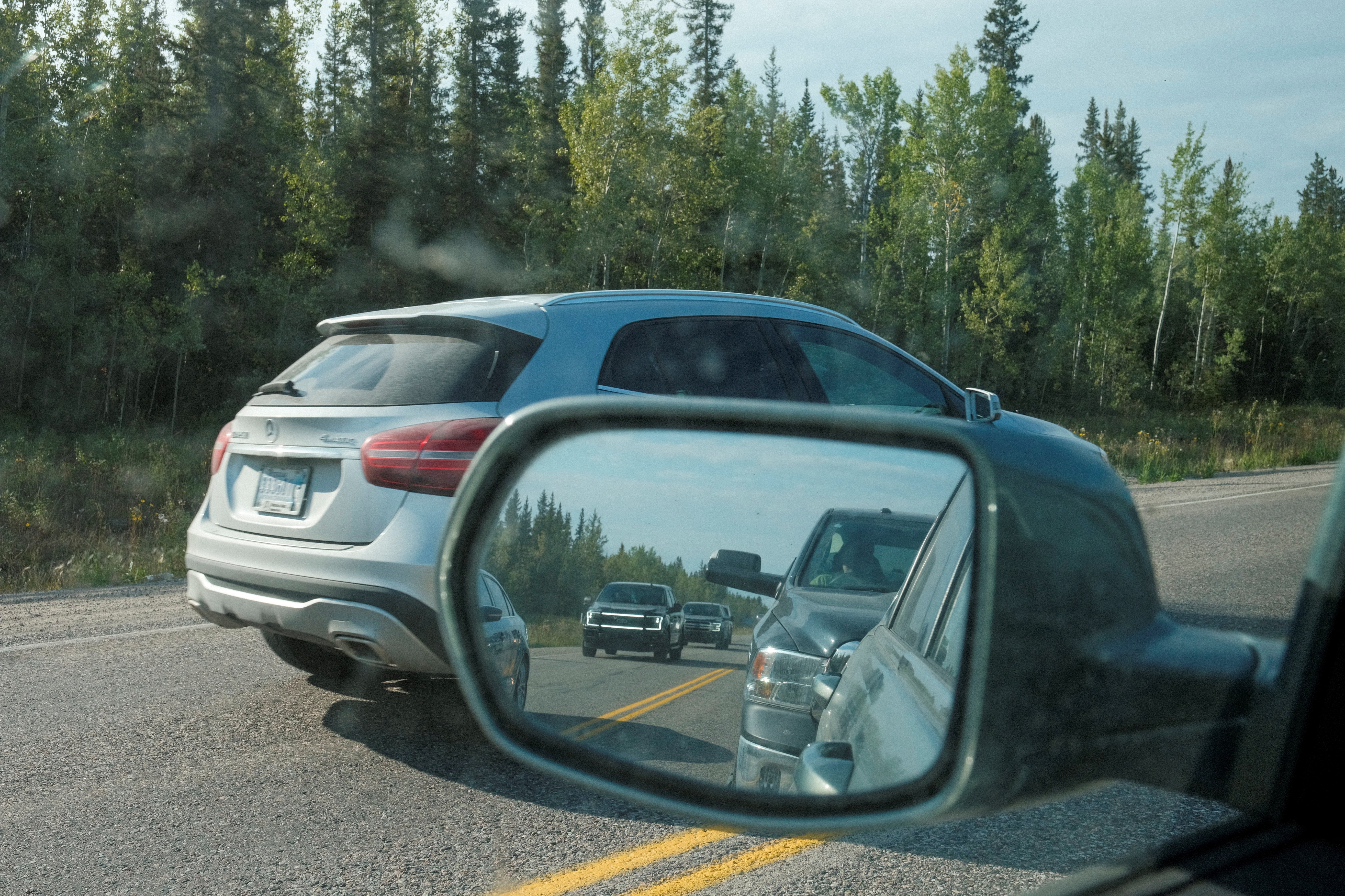 Cars pass a line of vehicles waiting for fuel, after an evacuation order was declared due to the proximity of a wildfire in Yellowknife, in Fort Providence, Northwest Territories, Canada August 17, 2023. Photo: Reuters