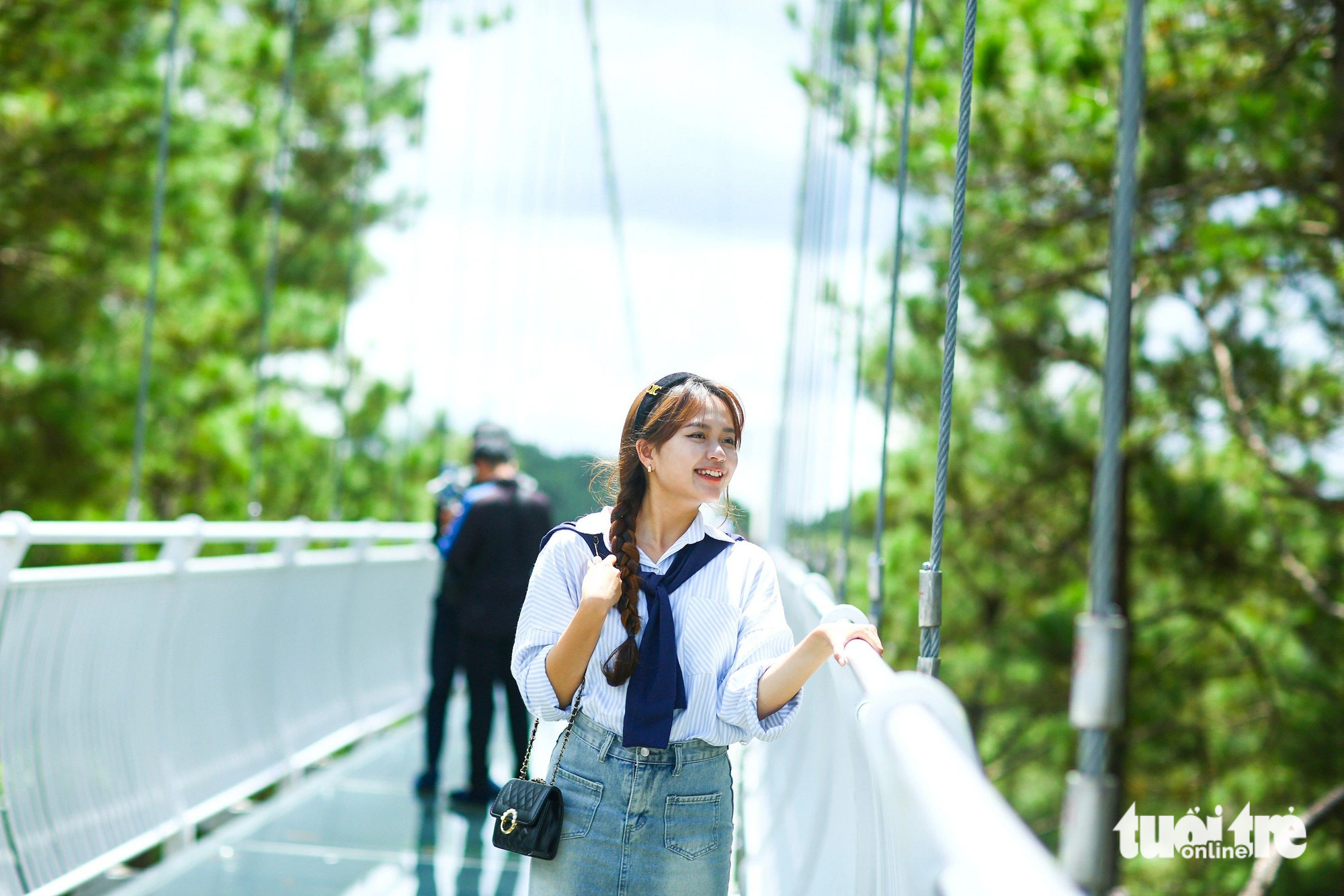 A visitor poses for a photo at the newly-launched Ngan Thong glass-bottomed bridge. Photo: Duc Tho / Tuoi Tre