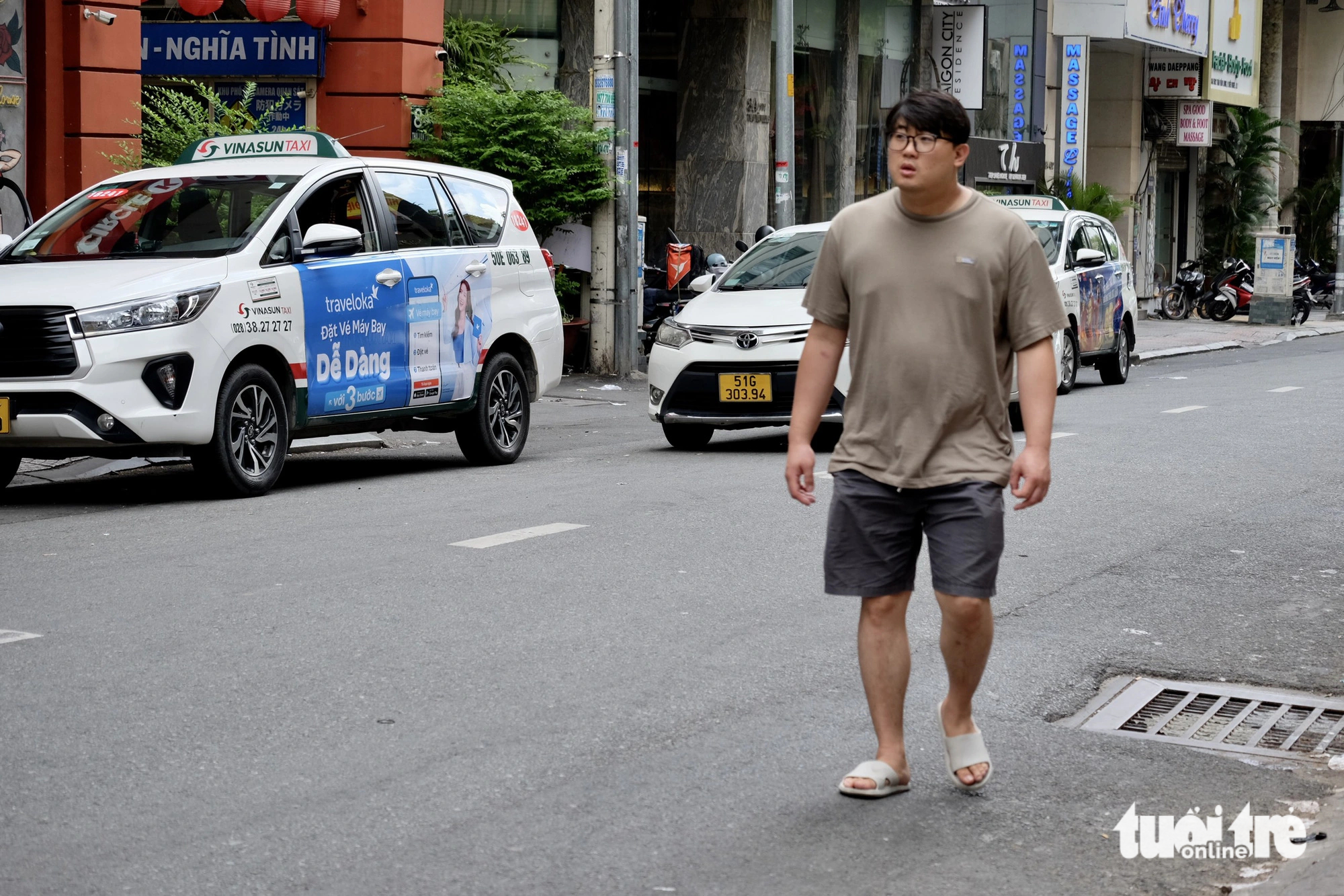 Local residents and tourists are forced into the roadway due to sidewalk encroachment. Photo: Tuoi Tre