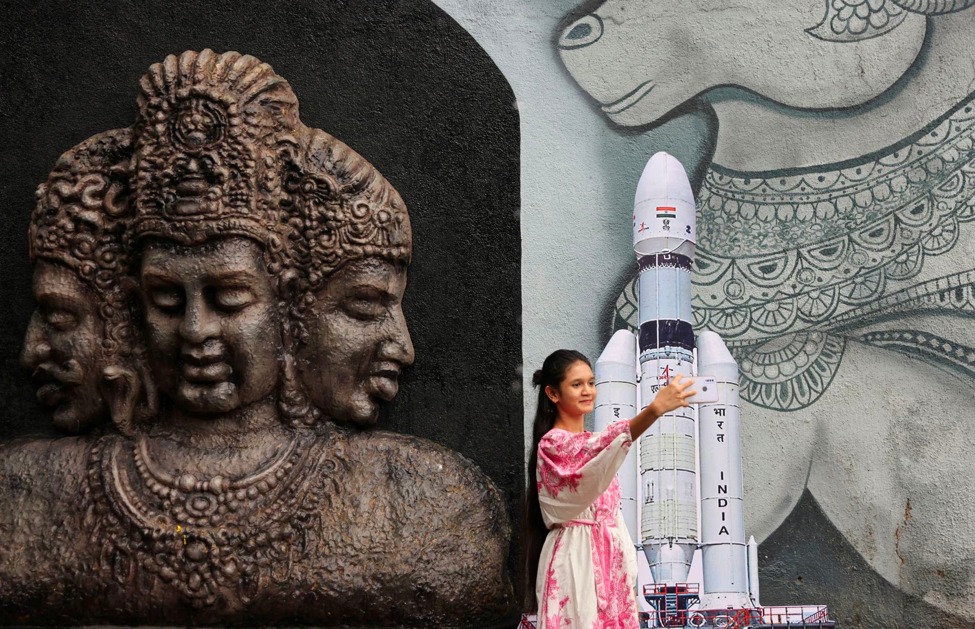 [2/3] A young woman takes a selfie along with a cutout of the Chandrayaan 3 Launch Vehicle Mark-III outside a temple in Mumbai, India, July 14, 2023. Photo: Reuters/Francis Mascarenhas/File Photo
