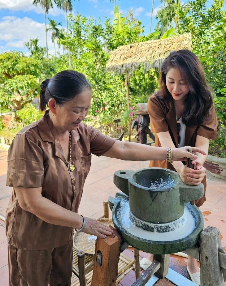 A local instructs a tourist to crush rice at her home which has been invested to run homestay service in Dai Binh Village, Nong Son District, Quang Nam Province. Photo supplied by Nong Son District People’s Committee