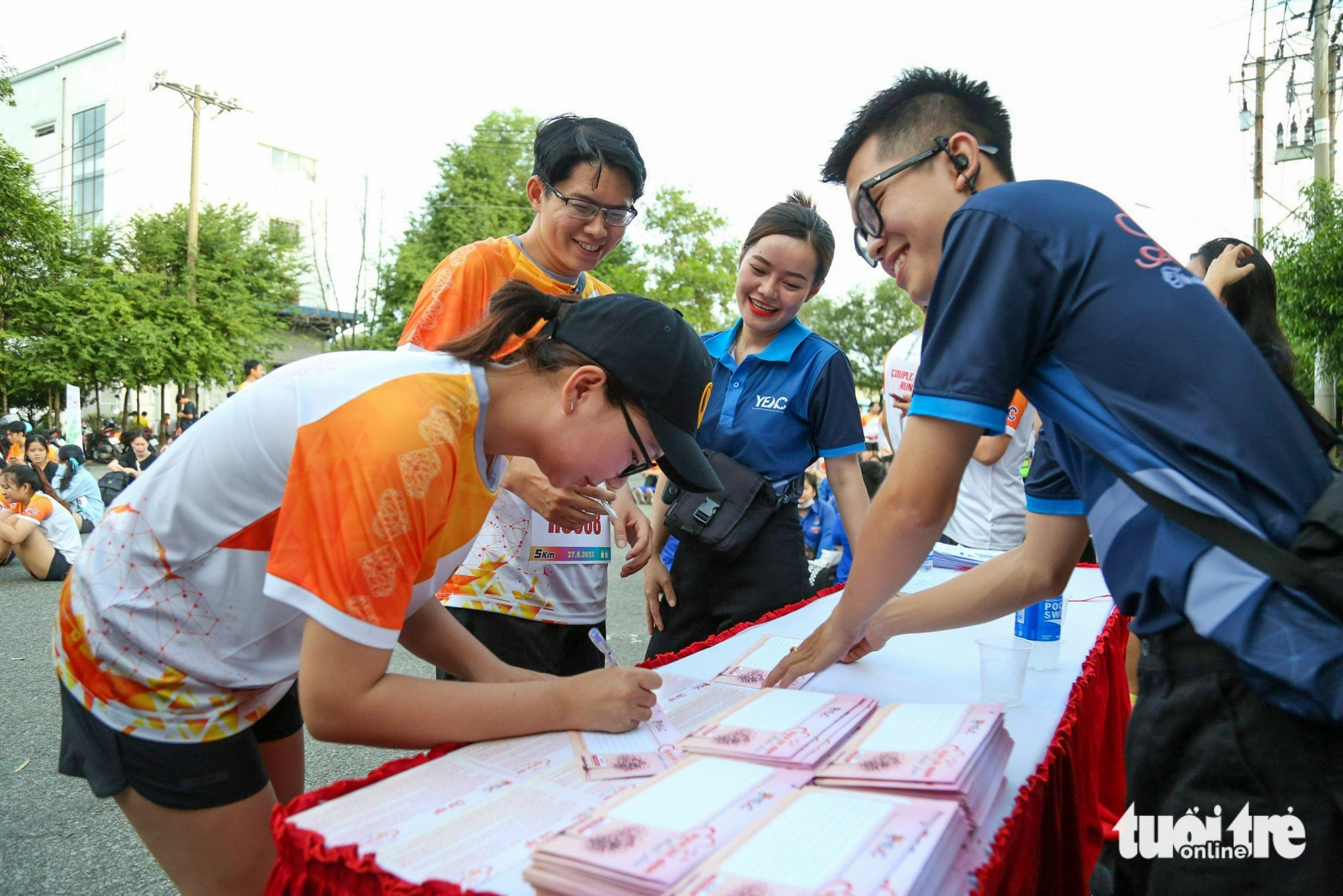 A runner writes wishes for couples of the mass wedding. Photo: Tuoi Tre