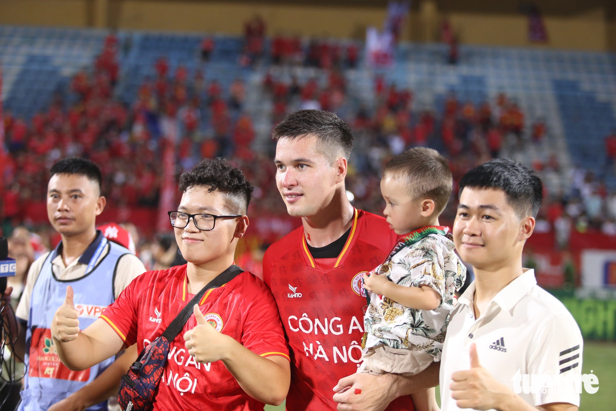 Cong An Hanoi FC’s Filip Nguyen holds his son to take photos with fans after winning the V-League 1 2023 at Hang Day Stadium in Hanoi, August 27, 2023. Photo: Nam Tran / Tuoi Tre