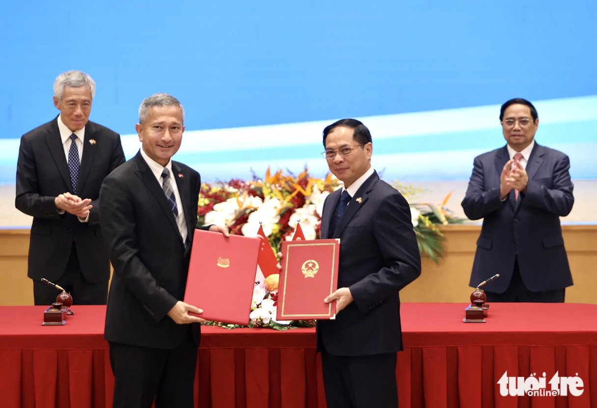 Minister of Foreign Affairs Bui Thanh Son (R) and Singaporean Minister for Foreign Affairs Vivian Balakrishnan swap a cooperative agreement. Photo: Nguyen Khanh / Tuoi Tre