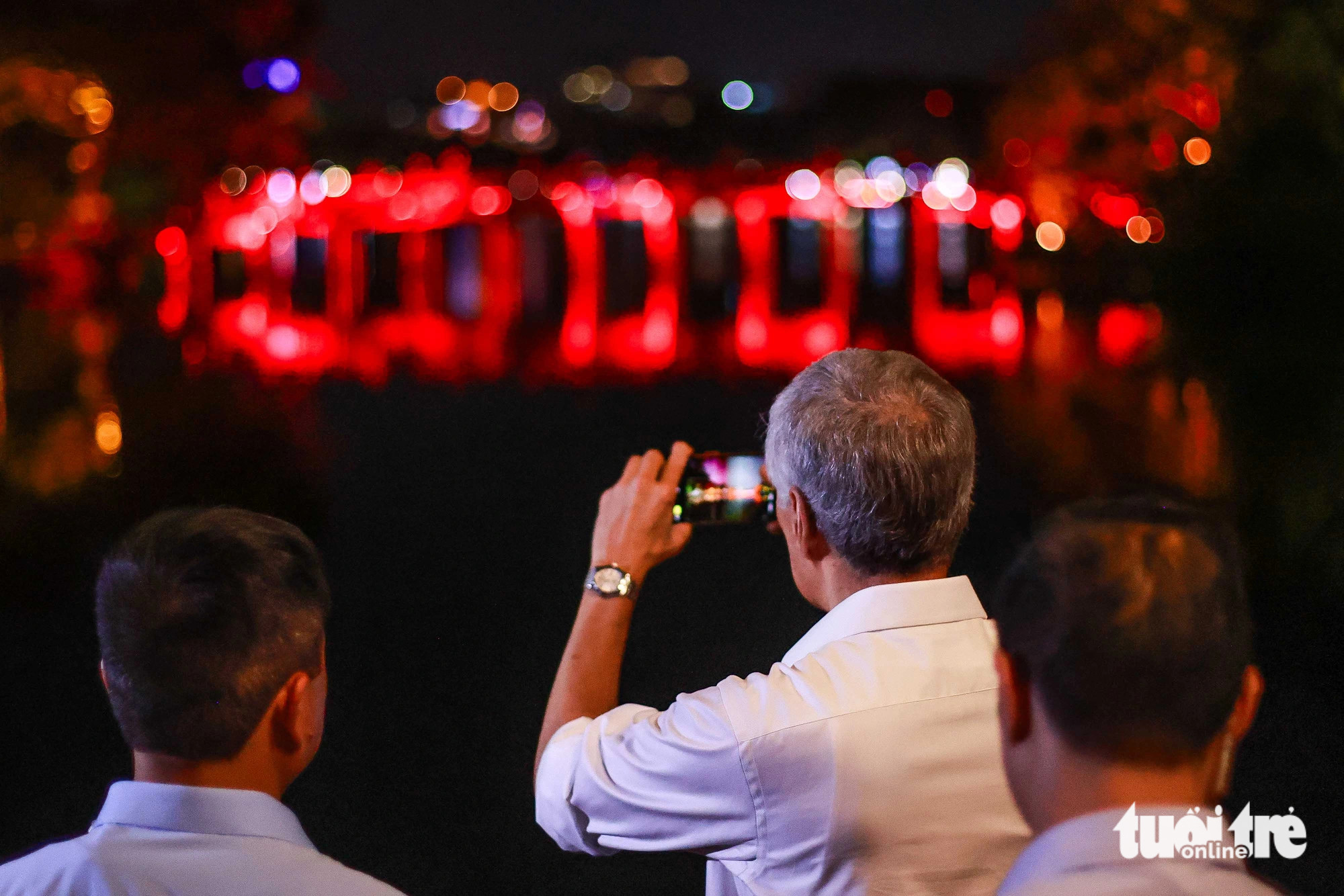 Prime Minister Lee Hsien Loong takes photos of The Huc Bridge at Hoan Kiem Lake in Hoan Kiem District, Hanoi, on the evening of August 27, 2023. Photo: Nguyen Khanh / Tuoi Tre