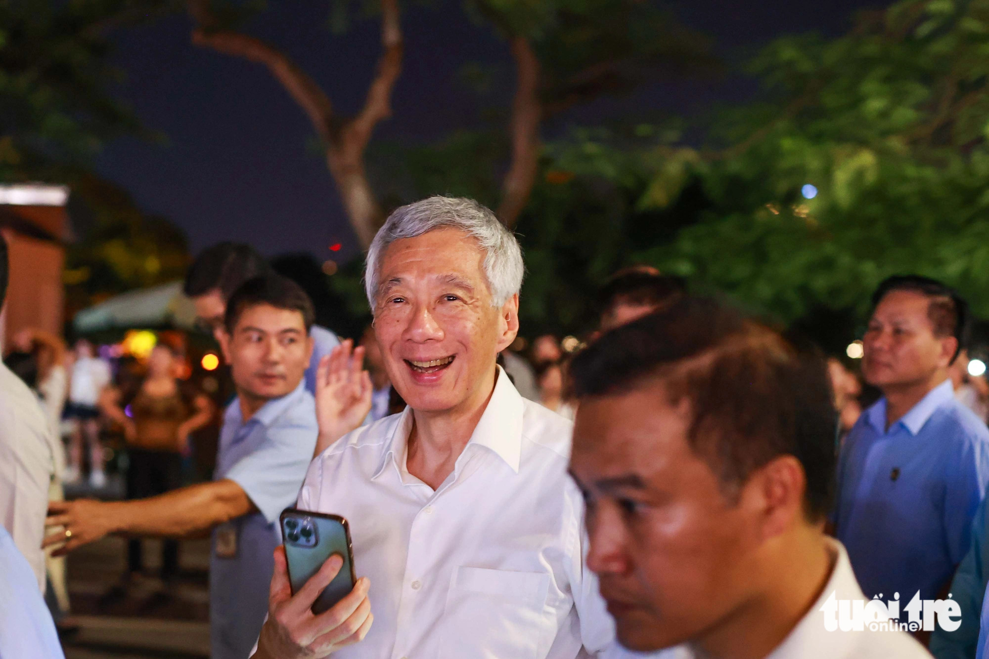 PM Lee Hsien Loong is pictured with a smile during his walk around Hoan Kiem Lake in Hanoi and his cellphone in hand to take photos of beautiful scenes, on the evening of August 27, 2023. Photo: Nguyen Khanh / Tuoi Tre