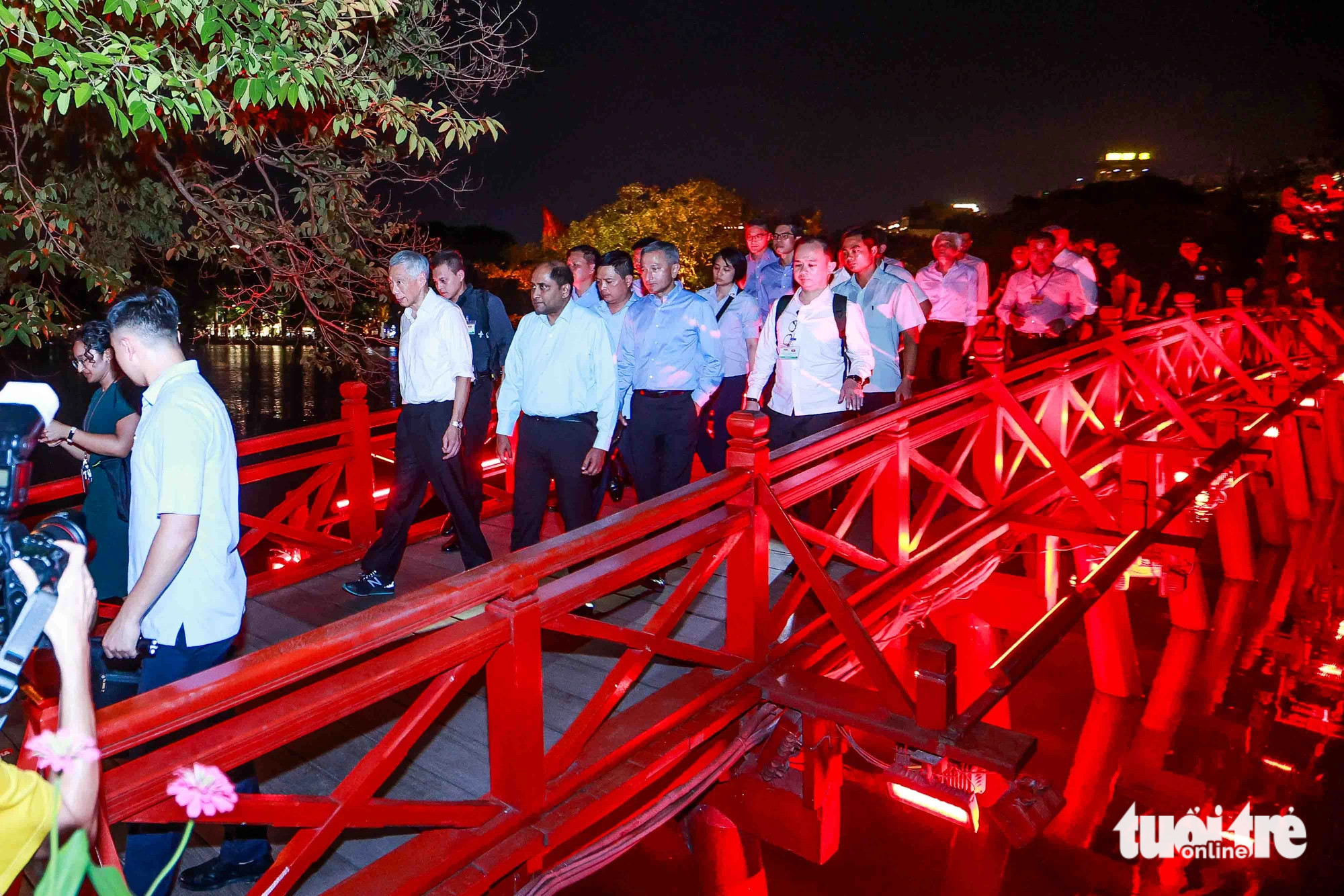 Prime Minister Lee Hsien Loong and his entourage walk on The Huc Bridge in Hanoi on the evening of August 27, 2023. Photo: Nguyen Khanh / Tuoi Tre