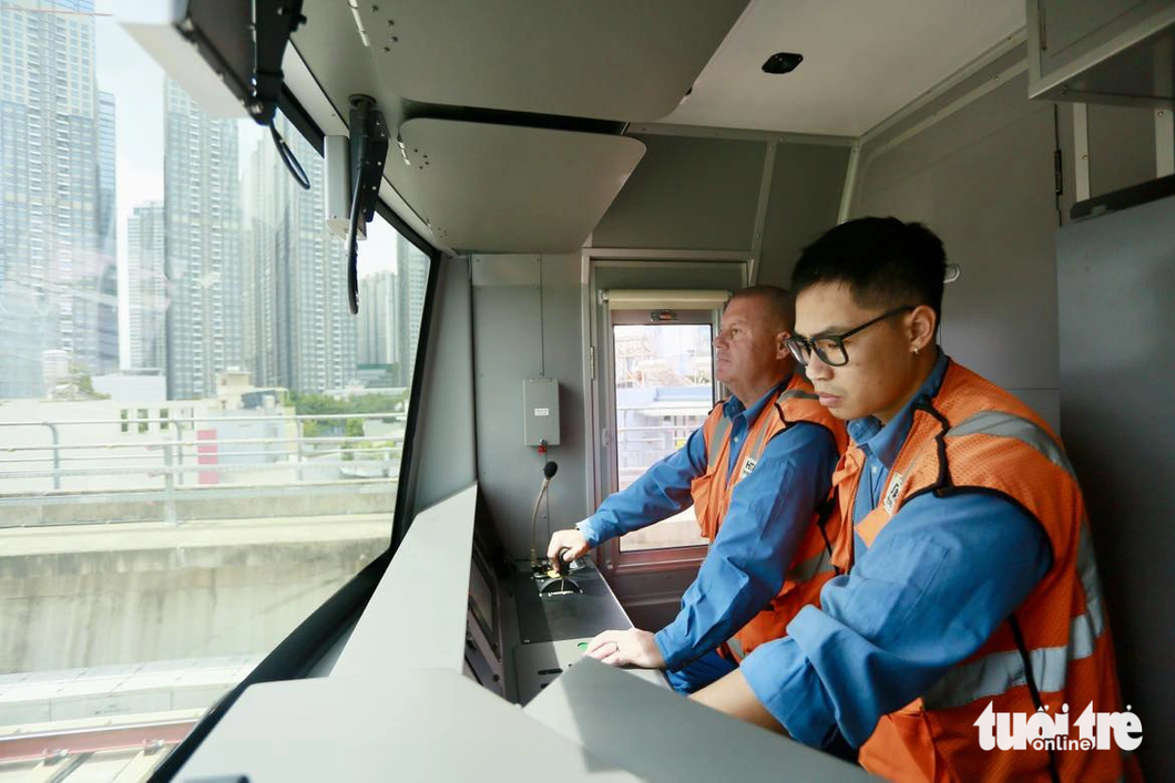 Two engineers in the cabin of a train of the first metro line in Ho Chi Minh City. Photo: Chau Tuan / Tuoi Tre