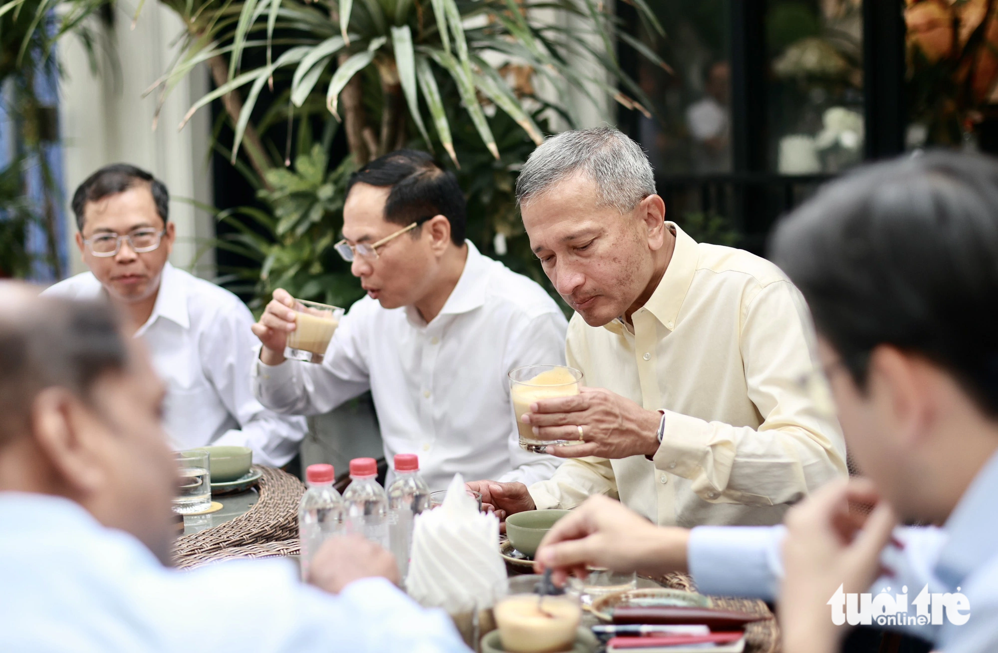 Singaporean Minister of Foreign Affairs Vivian Balakrishnan (in the beige shirt) enjoys a cup of egg coffee at a sidewalk café in Hanoi, August 29, 2023. Photo: Nguyen Khanh / Tuoi Tre