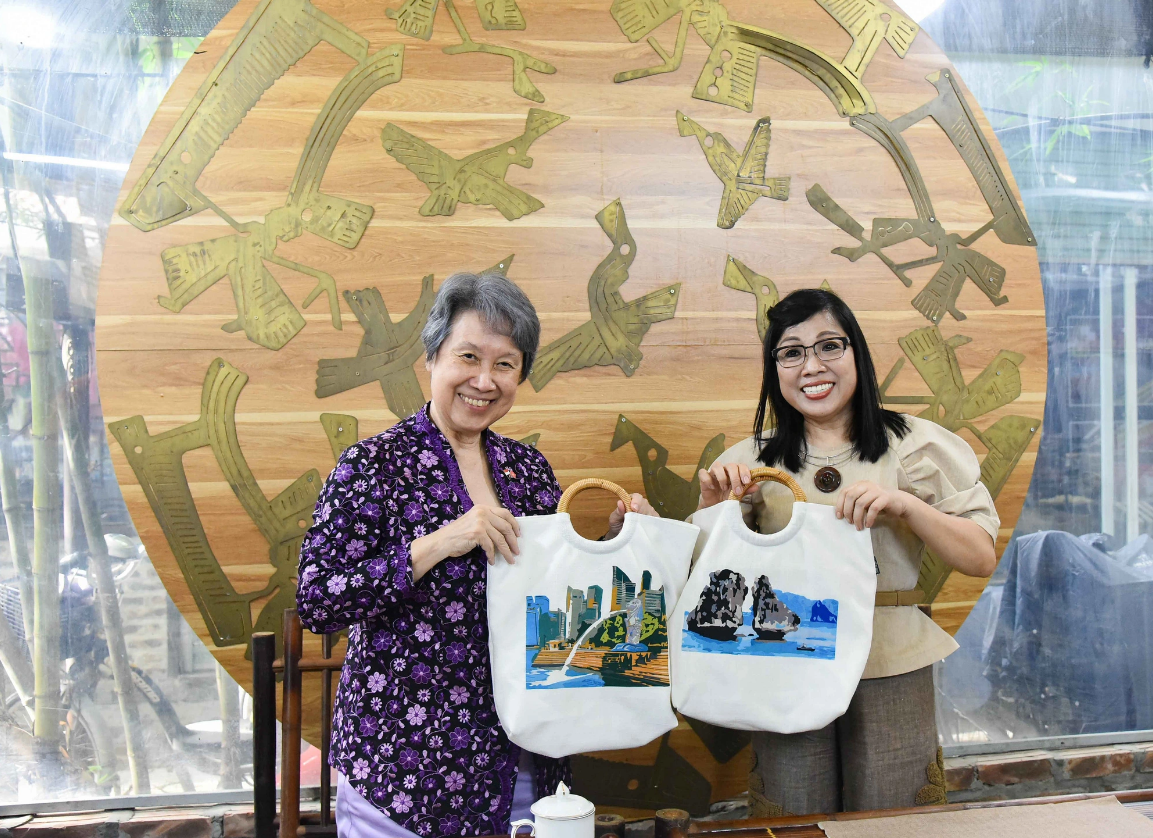 Prime Minister Pham Minh Chinh’s spouse Le Thi Bich Tran (R) and Singaporean Prime Minister Lee Hsien Loong’s spouse Ho Ching pose for a photo with each other’s picture made of silk scraps. Photo: Hong Nguyen / Tuoi Tre