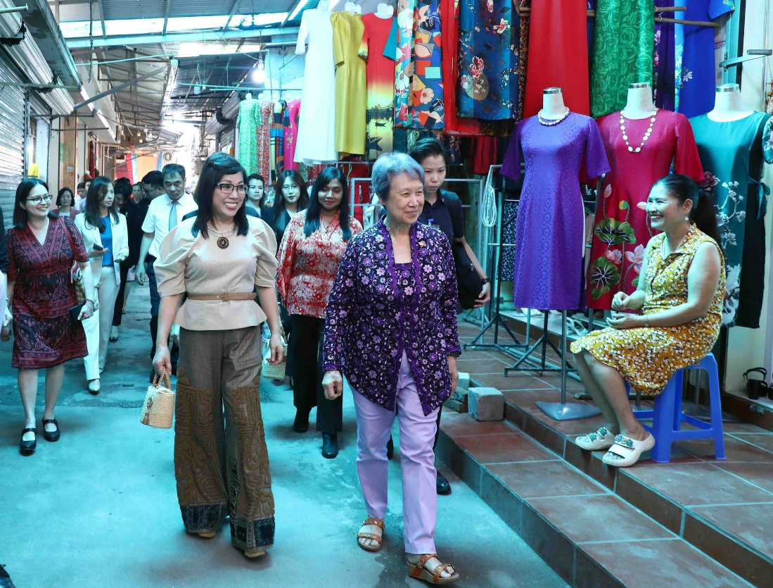 The two spouses of the top Vietnamese and Singaporean officials take a stroll around the Van Phuc Silk Village. Photo: Vietnam News Agency
