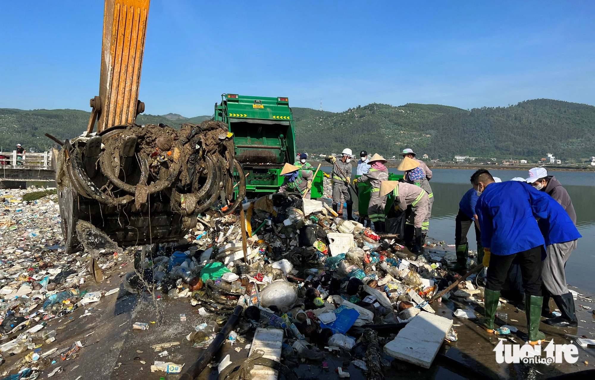 Young volunteers and employees of Quang Ngai Urban Environment JSC collect trash at Sa Huynh lagoon. Photo: Tran Mai / Tuoi Tre