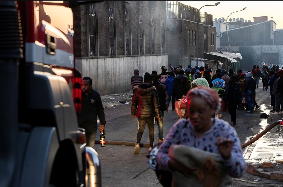 People walk past a building after a deadly blaze in the early hours of the morning, in Johannesburg, South Africa August 31, 2023. Photo: Reuters