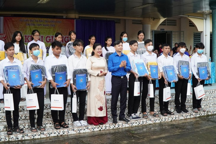 Secretary of the Central Committee of the Ho Chi Minh Communist Youth Union Nguyen Minh Triet (in the blue shirt) gives scholarships to students at Mang Thit High School in southern Vinh Long Province. Photo: Chi Hanh / Tuoi Tre