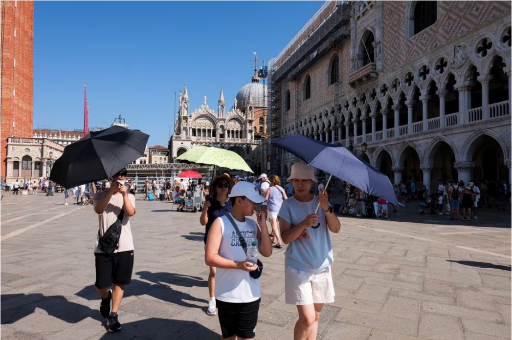 Tourists walk during a new heatwave as temperatures are expected to reach 40 degrees Celsius in some cities, in Venice, Italy August 22, 2023. Photo: Reuters