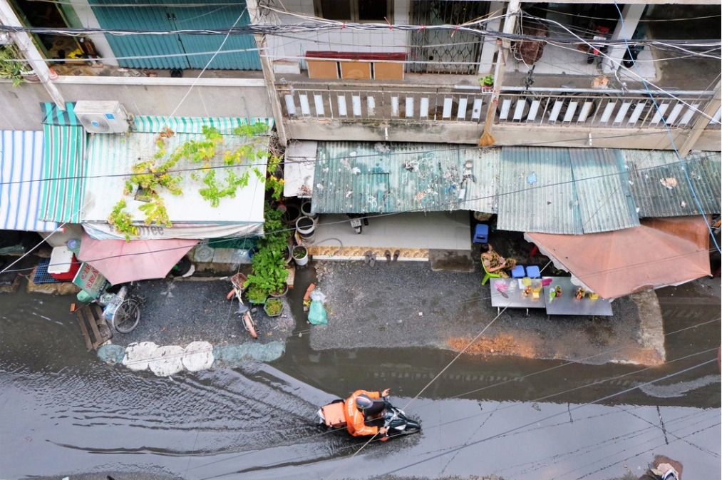 Some households on the ground floor of An Quang apartment building pour sand in front of their apartments to prevent the drainage water from flowing into their apartments. Photo: Phuong Nhi / Tuoi Tre