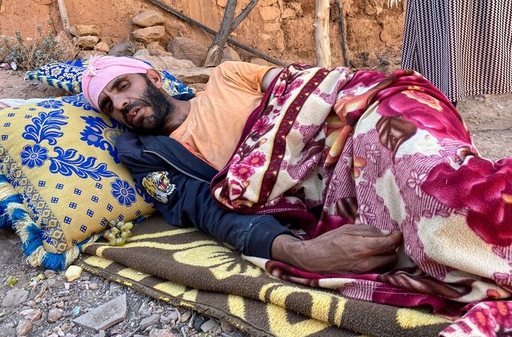 Abdellatif Ait Bella, who was injured in the earthquake that destroyed his home, lies on the ground as he and his wife Saida Bodchich prepare to spend a second night in the open air, in the village of Tansghart in the Asni area, Morocco, September 9, 2023. Photo: Reuters