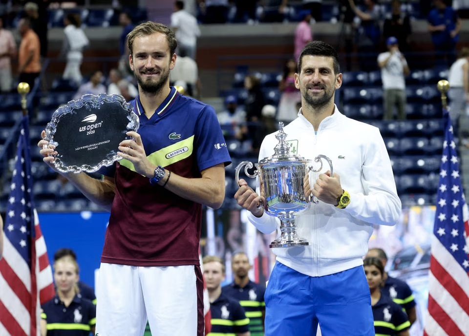 Tennis - U.S. Open - Flushing Meadows, New York, United States - September 10, 2023 Serbia's Novak Djokovic celebrates with the trophy after winning the U.S. Open beside second place Russia's Daniil Medvedev. Photo: Reuters