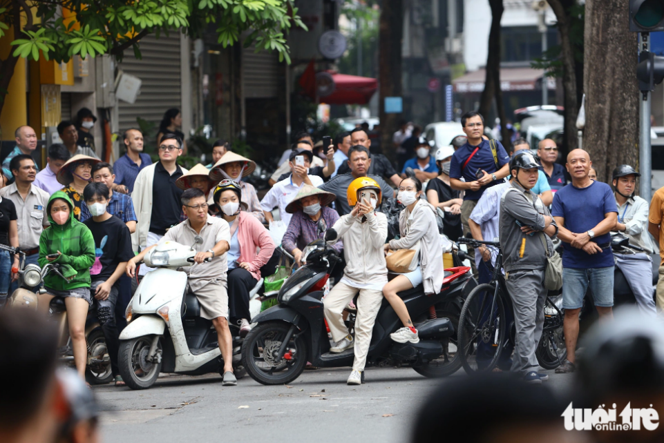 Hanoians take a look at the U.S. president's convoy of cars. Photo: Danh Khang / Tuoi Tre
