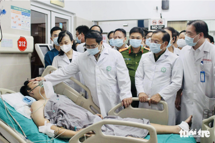 Prime Minister Pham Minh Chinh visits a victim of the fire receiving treatment at Hanoi-based Bach Mai Hospital. Photo: Duong Lieu / Tuoi Tre