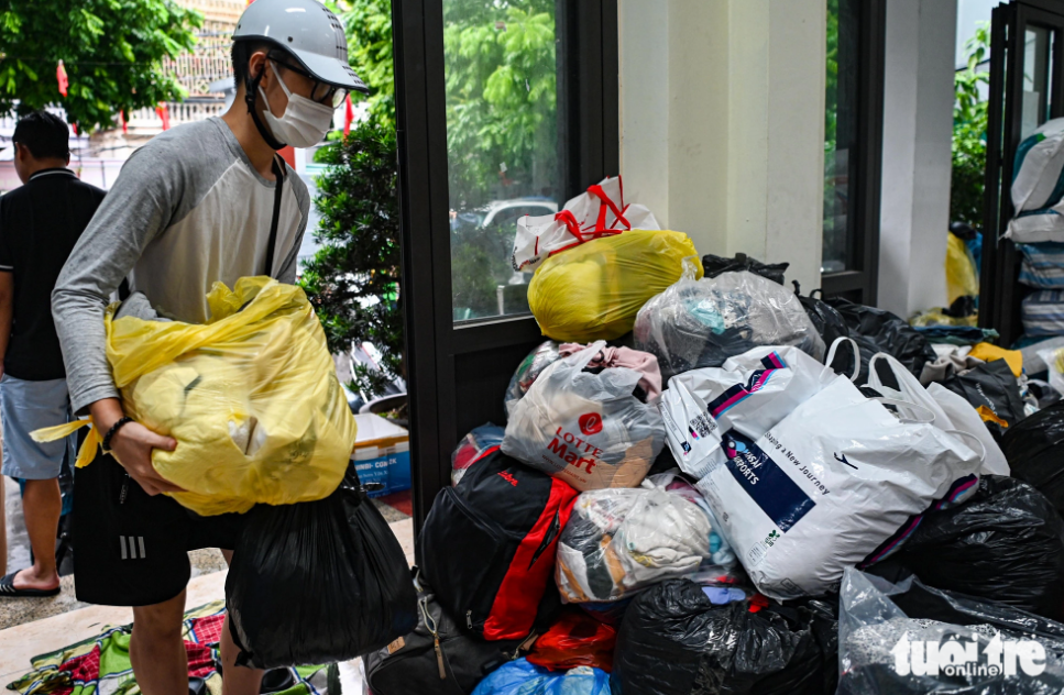 Bui Sy Thai, a 19-year-old student at the National Economics University, traveled nearly three kilometers to donate clothes to victims. “I wanted to lend a helping hand to the victims so that they can overcome the huge loss,” Thai said. Photo: Hong Quang / Tuoi Tre