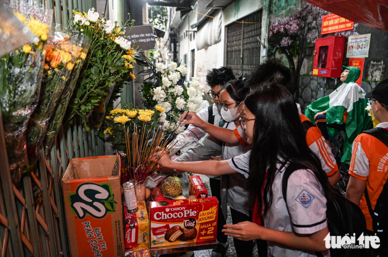Students offer incense and pay homage to friends who lost their lives in the fatal blaze. Photo: Hong Quang / tuoi Tre