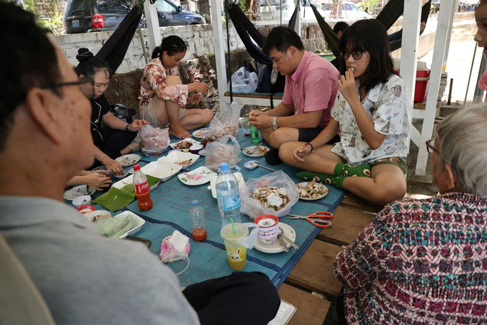 Sokunchanpimien Thun, 16 years old, eats crabs with her family by the sea near the crab market in Kep Province, Cambodia, August 18, 2023. Photo: Reuters