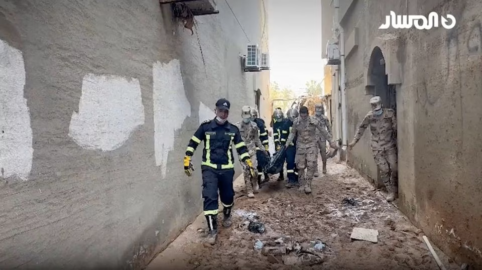 Rescue workers carry a dead body amidst rescue operations in the aftermath of the floods in Derna, Libya September 13, 2023 in this screen grab obtained from a video. AL-Masar TV/Handout via Reuters