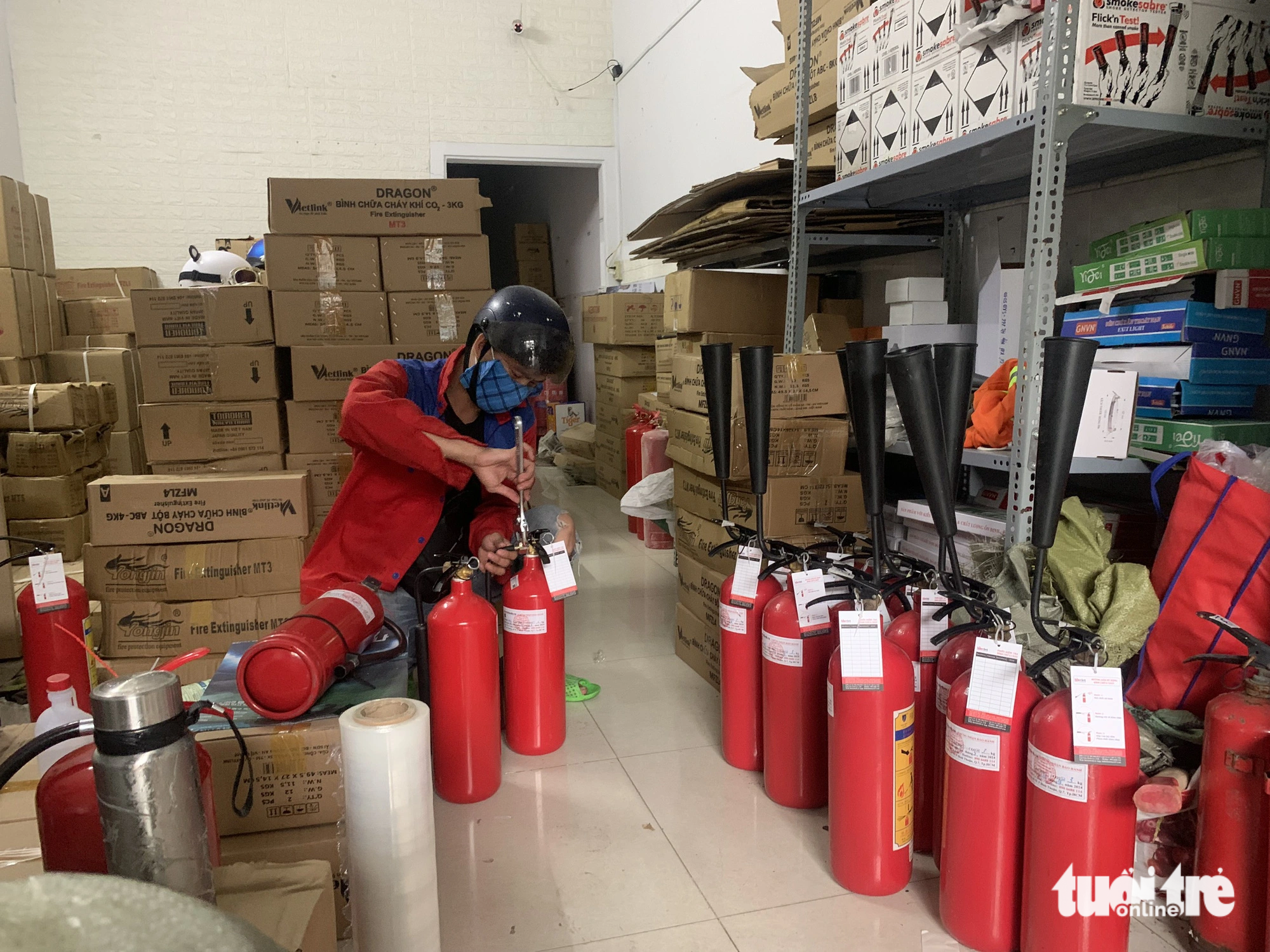 An employee of Lua Viet Co. Ltd., a supplier of fire safety equipment in District 7, Ho Chi Minh City, checks fire extinguishers before delivering them to customers. The company’s orders have surged after the fire at an apartment block in Hanoi on September 12, 2023. Photo: Quoc Viet / Tuoi Tre