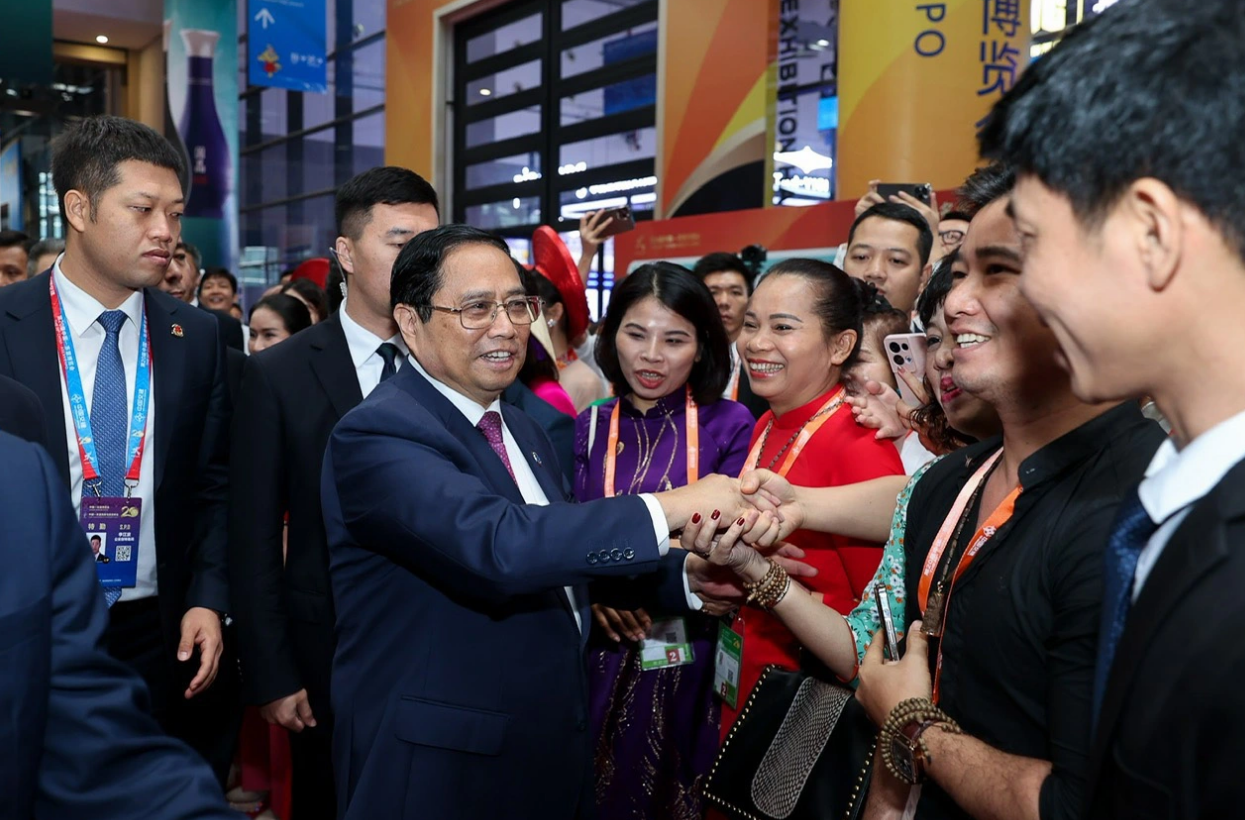 Prime Minister Pham Minh Chinh (L) shakes hands with some representatives of Vietnamese firms that are participating in the 20th China-ASEAN Expo in Nanning, China. Photo: Nhat Bac / Tuoi Tre