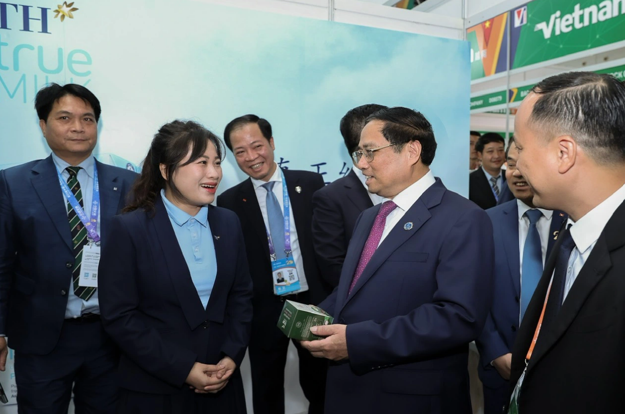 Prime Minister Pham Minh Chinh (2nd, right) talks to a representative of a participating firm. Photo: Nhat Bac / Tuoi Tre
