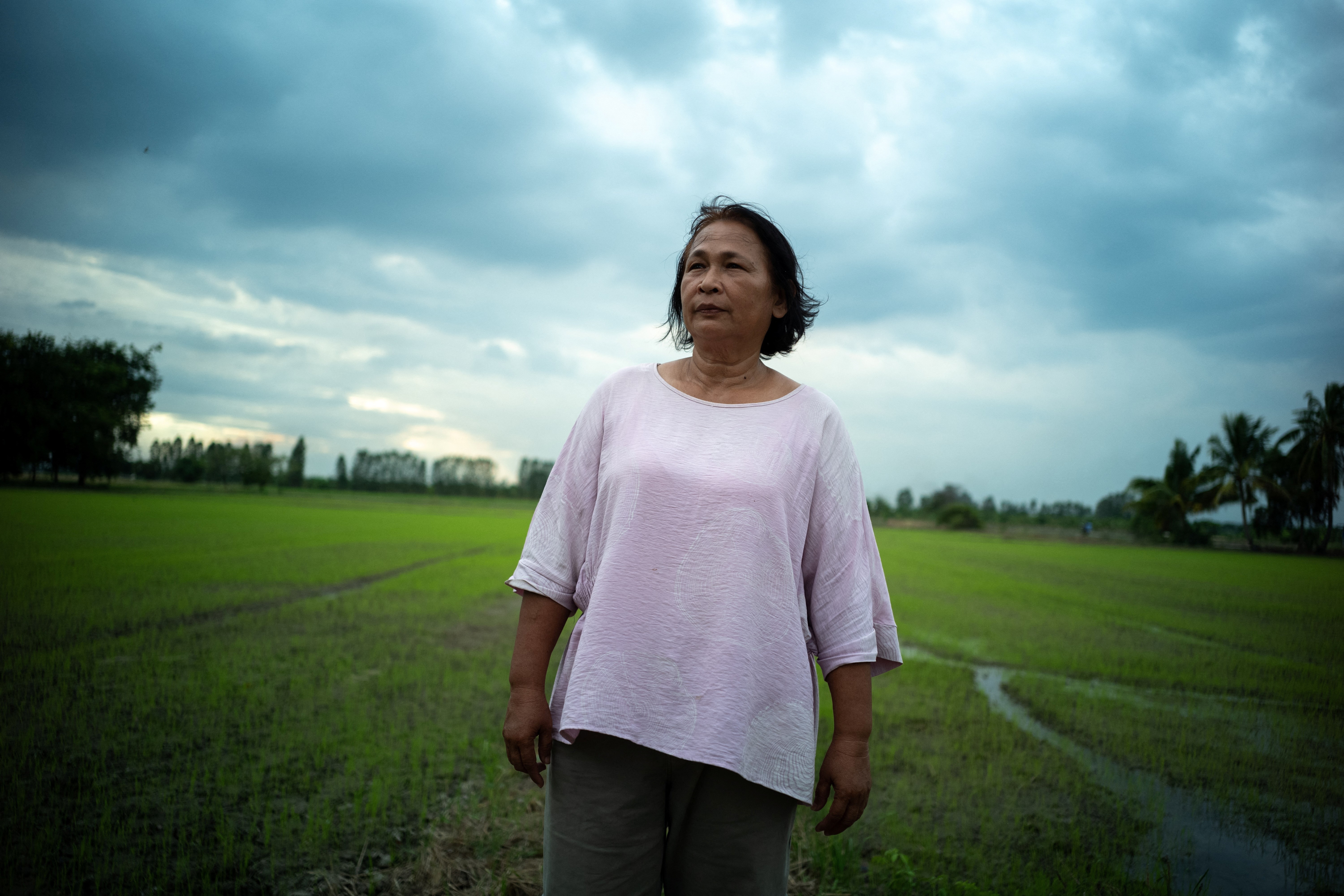 Sripai Kaeo-eam, 58, a farmer who is struggling to repaying her loans, poses in front of her rice field during an interview with Reuters in Chainat province, Thailand, August 30, 2023. Photo: Reuters