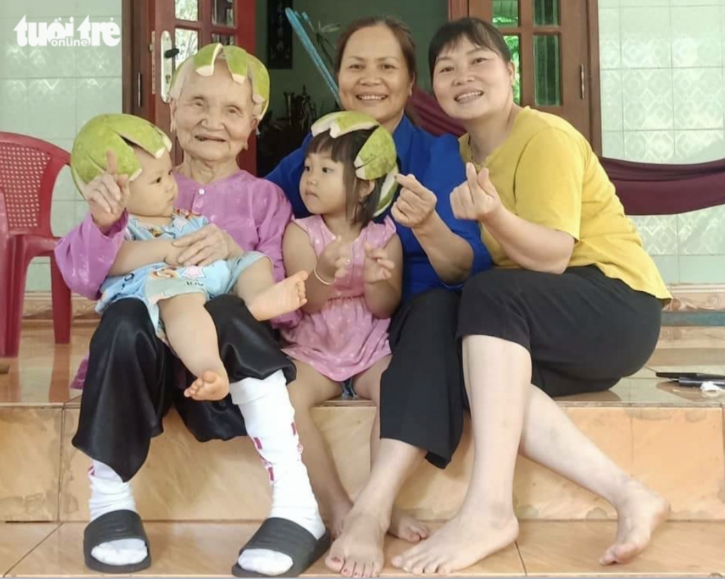 The elderly woman, named Ket, (R) poses for a photo with her family members. Photo: Yen Trinh / Tuoi Tre