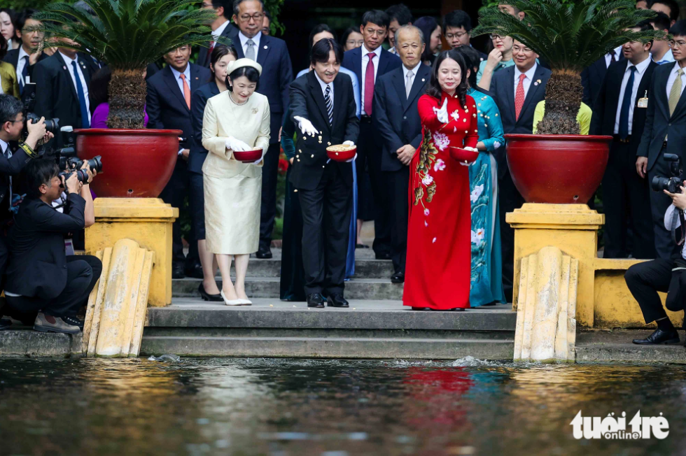 Vice-State President Vo Thi Anh Xuan (R), Japanese Crown Prince Akishino (C) and Crown Princess Kiko (L) are pictured feeding fish in late President Ho Chi Minh’s fish pond. The fish pond covers an area of more than 3,000 square meters. Photo: Nguyen Khanh / Tuoi Tre
