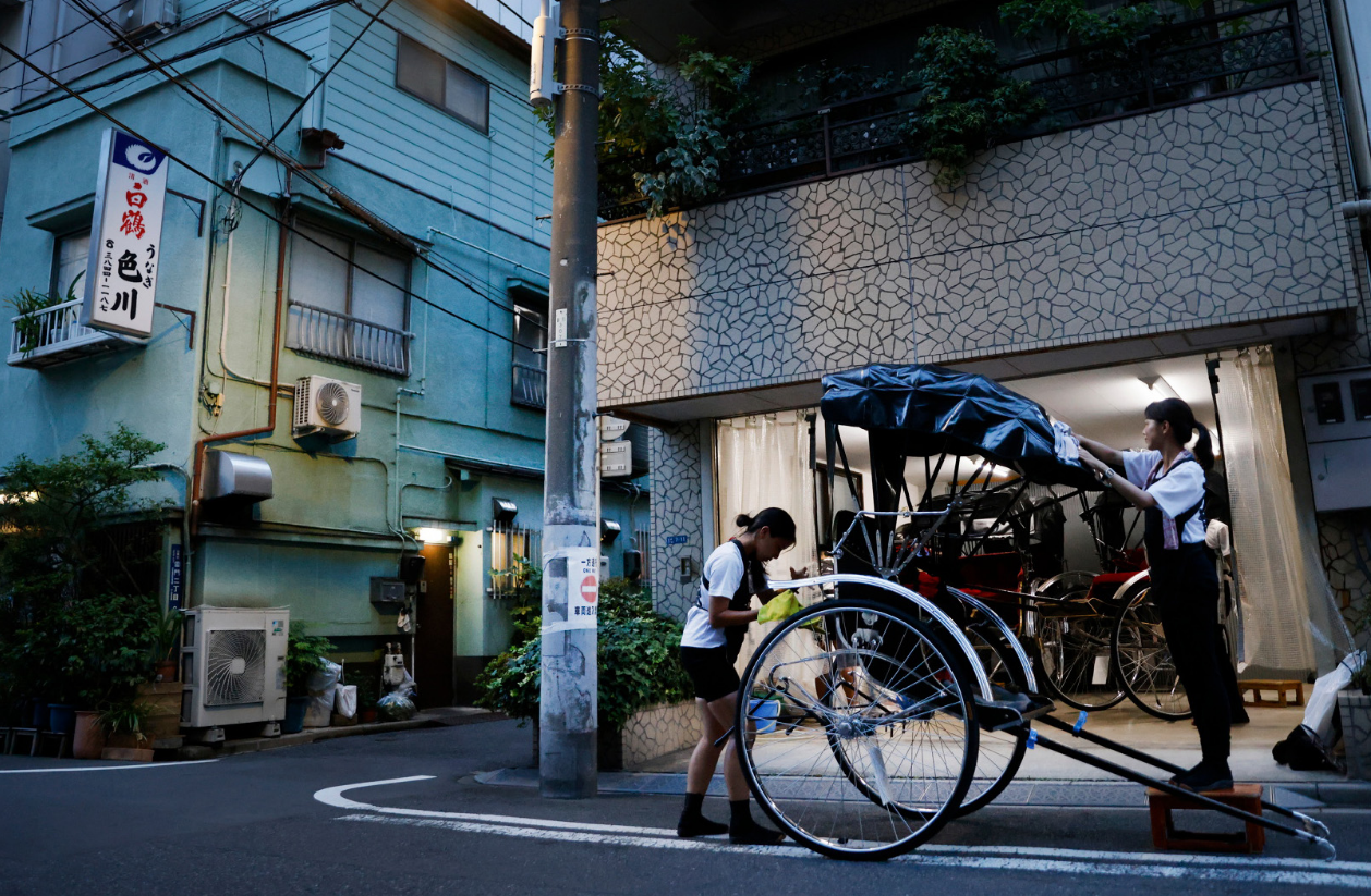 Pullers Akina Suzuki (left) and Misato Otoshi, 30, clean up their rickshaw after work at a garage in the Asakusa district, Tokyo, Japan, August 17, 2023. Photo: Reuters