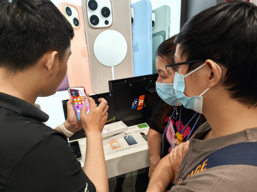 A FPT Shop employee instructs customers to use the iPhone 15. Photo: Duc Thien / Tuoi Tre