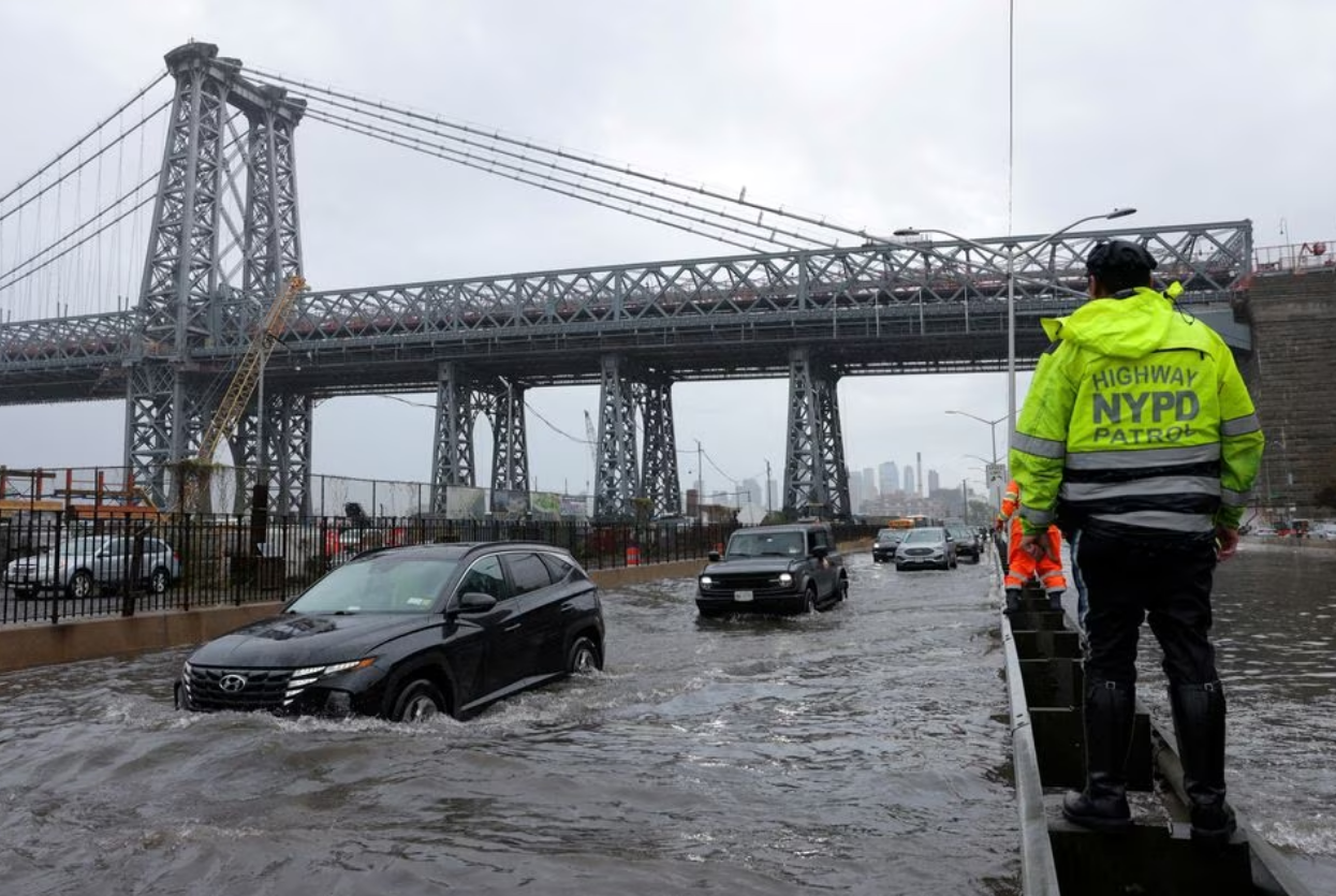 A police officer from the NYPD Highway Patrol looks on as motorists drive through a flooded street after heavy rains as the remnants of Tropical Storm Ophelia bring flooding across the mid-Atlantic and Northeast, at the FDR Drive in Manhattan near the Williamsburg Bridge, in New York City, U.S., September 29, 2023. Photo: Reuters