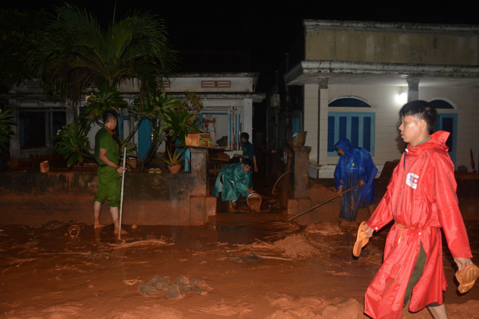 Police forces help locals remove sand and mud from their houses. Photo: Tuoi Tre