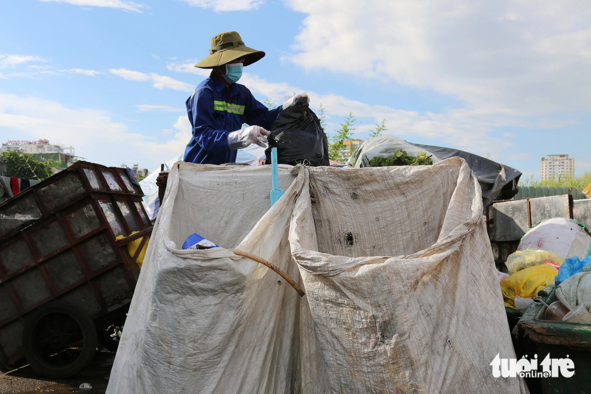 A sanitation worker is seen classifying used plastic bags