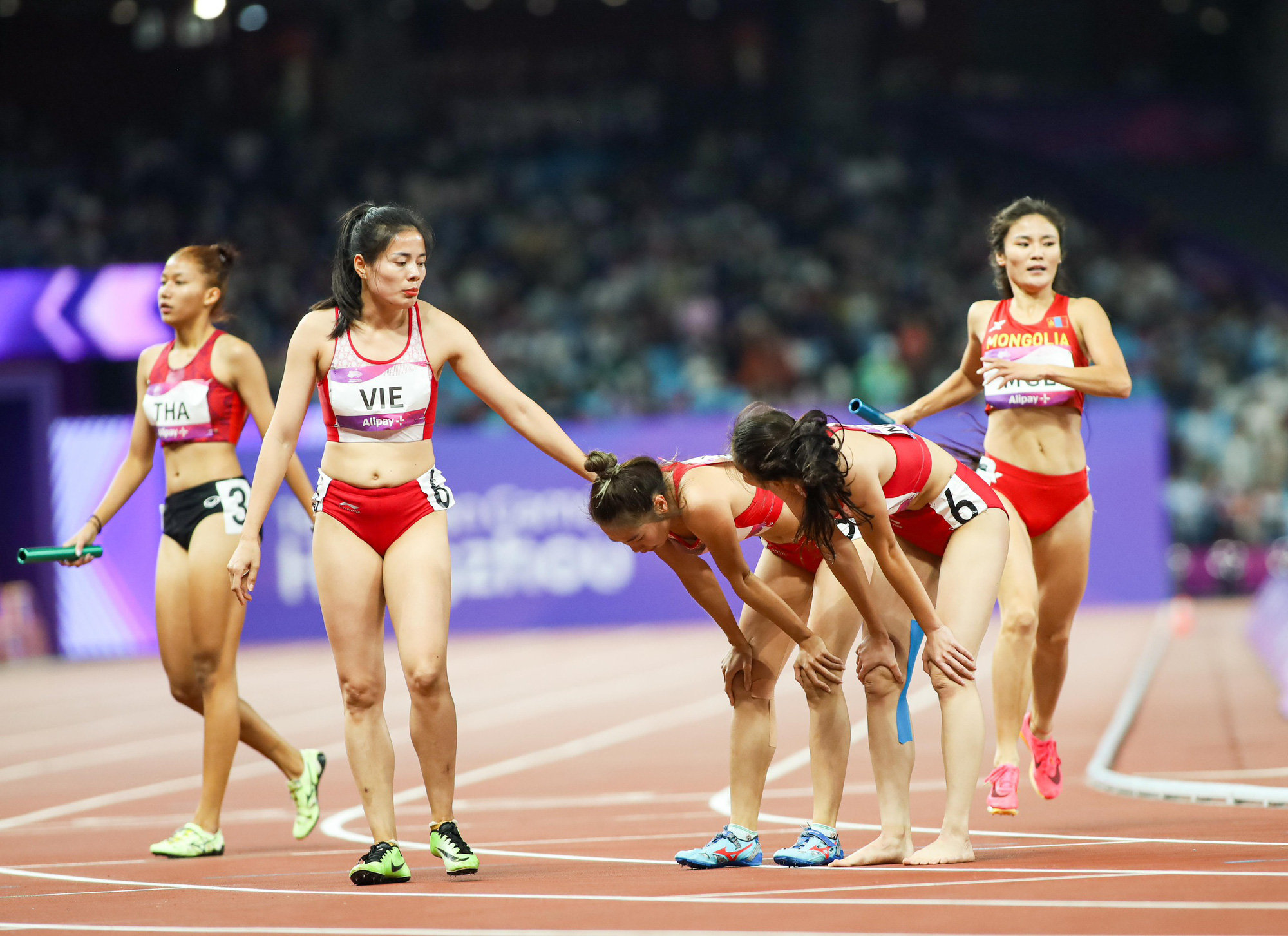 Vietnamese athlete Nguyen Thi Huyen (L, 2nd) comforts her teammates after they finished fourth in the women’s 4x400m relay event at the 19th Asian Games in Hangzhou, China, October 4, 2023. Photo: Duc Khue / Tuoi Tre