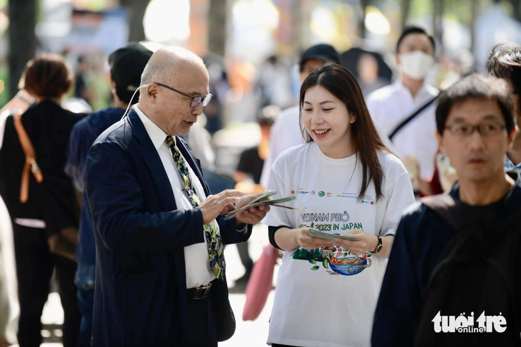 A volunteer instructs a visitor to the Vietnam Pho Festival 2023 at Yoyogi Park in Tokyo on October 7, 2023. Photo: Quang Dinh / Tuoi Tre