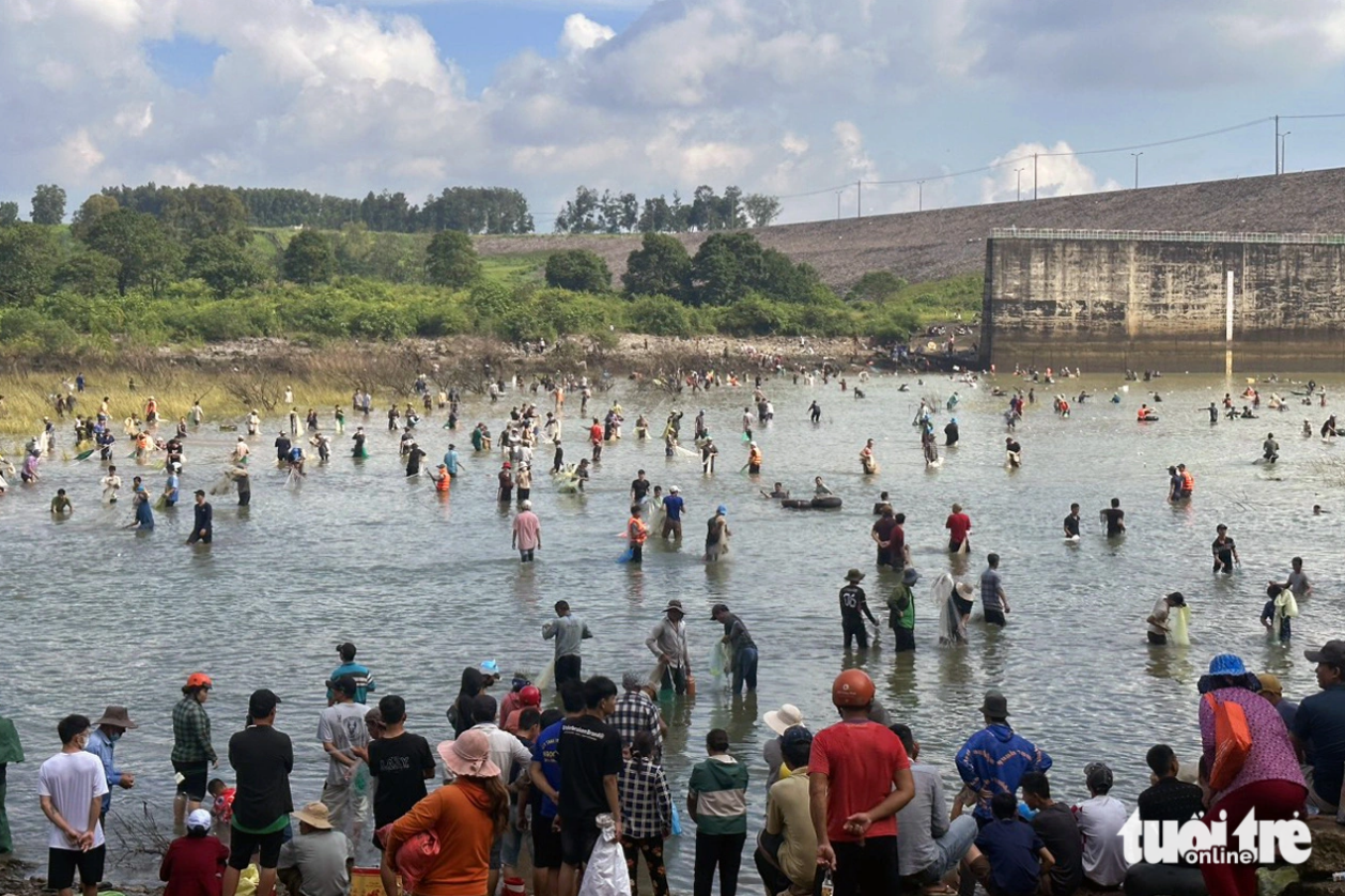 The foot of the Tri An hydroelectric dam in Dong Nai Province, southern Vietnam crowded with fish hunters. Photo: Tuoi Tre