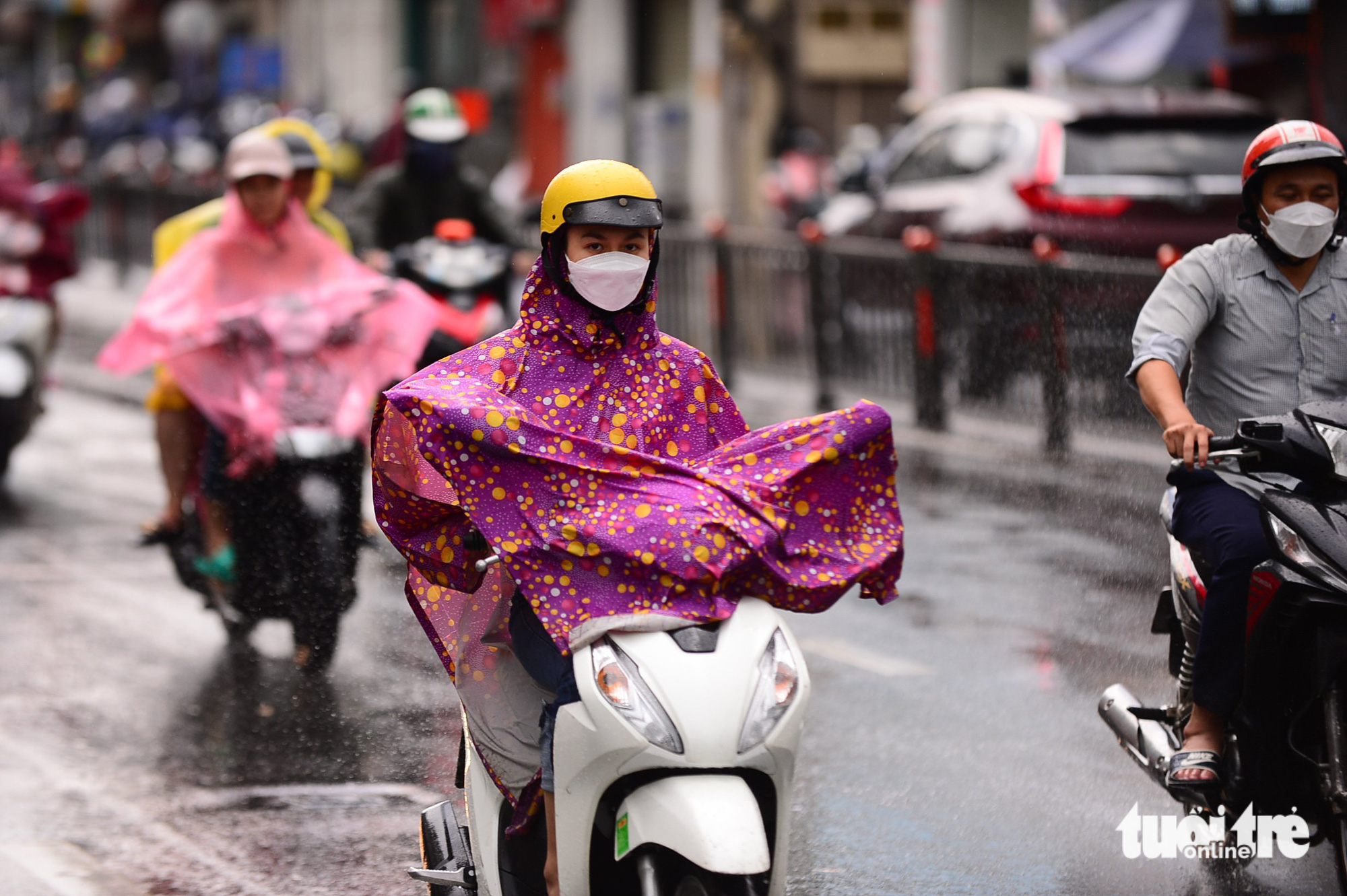Commuters wear raincoats along a street in Ho Chi Minh City. Photo: Quang Dinh / Tuoi Tre
