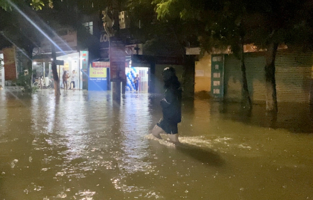 A resident of Da Nang City walks through the floodwater on Nguyen Nhan Street in Cam Le District. Photo: Truong Trung / Tuoi Tre