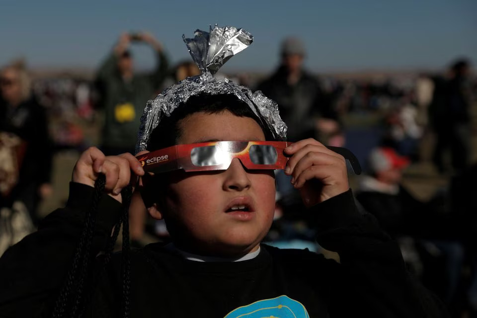Ten-year-old Ezra Martinez watches the annular solar eclipse at the Albuquerque International Balloon Fiesta in Albuquerque, New Mexico, U.S., October 14, 2023. Photo: Reuters