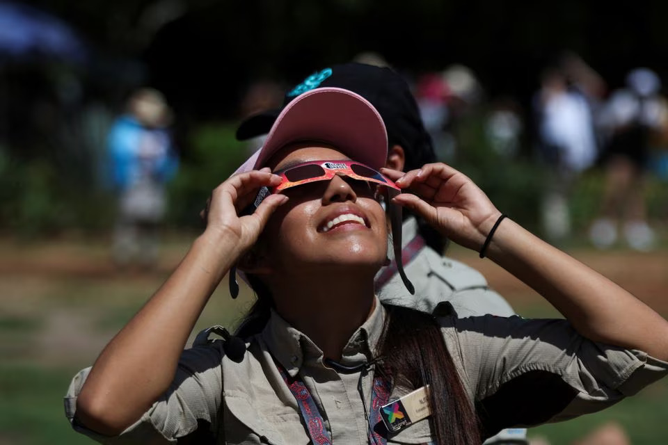 A person uses protective glasses to watch the solar eclipse at the Chichen Itza archaeological zone, in Piste, Mexico, October 14, 2023. Photo: Reuters